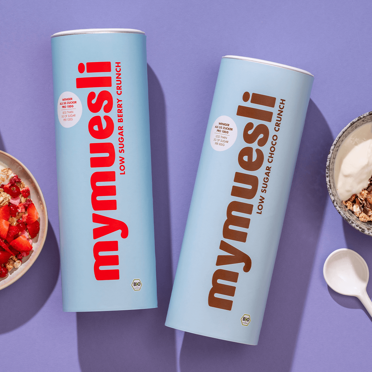 mymuesli Low Sugar Berry Crunch und Low Sugar Choco Crunch Müslis neben Schalen