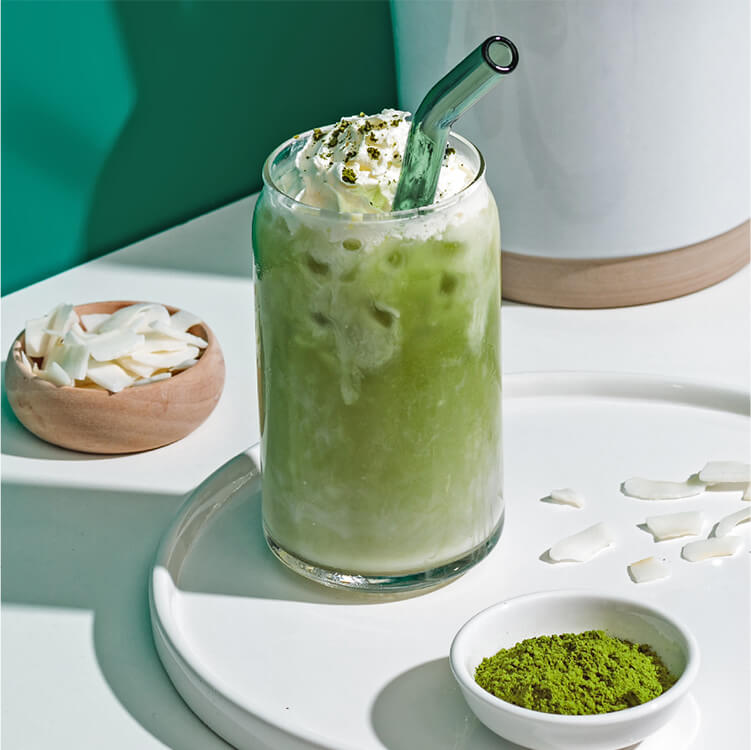 Iced Matcha Latte im Glas mit Strohhalm