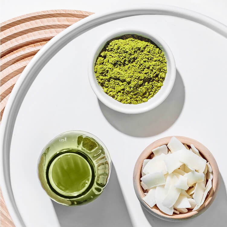 Schüsseln mit Matcha Pulver und Kokosraspeln