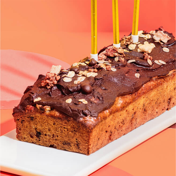 Bananenbrot auf einem Teller mit Kerzen und Konfetti
