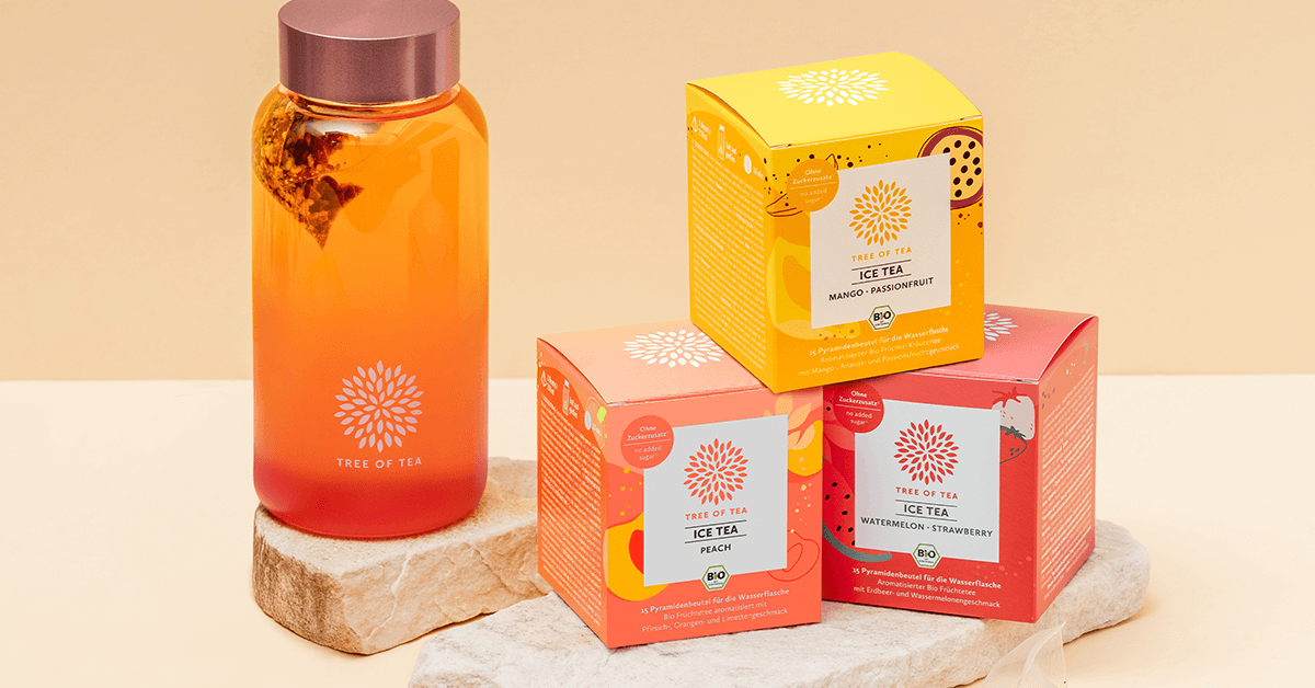 Tree of Tea Ice Tea Starter Set mit Mango Passionfruit, Peach, Watermelon Strawberry und rosa Ice Tea Bottle auf einer Steinplatte vor minimalistischem Hintergrund.