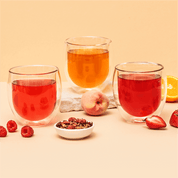 Tree of Tea Früchtetee Set in 3 Teegäsern neben frischem Obst und getrockneten Tee in Schalen