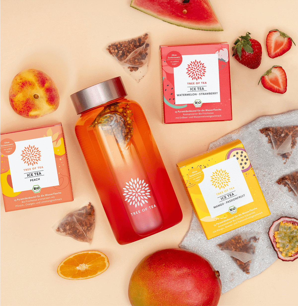 Tree of Tea Ice Tea Starter Set mit einer aufgefüllten Ice Tea bottle in Rosa. Drumherum liegen die enthaltenen Ice Tea Sorten mit frisch aufgeschnittenen Erdbeeren, Wassermelone, Pfirsich, Mango und Passionsfrucht.