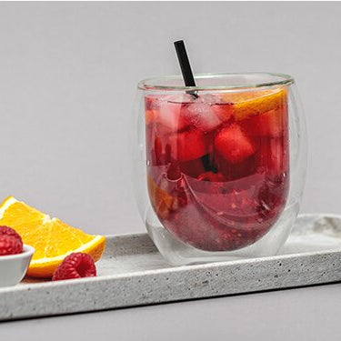 Raspberry Ruby Cocktail auf einem Tablett mit dem Teamaker daneben