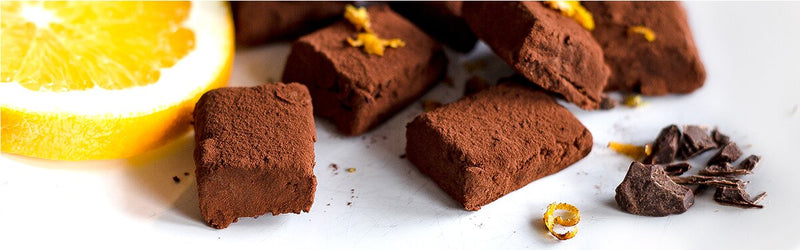 Schokoladenkonfekt mit Miss Grey und einer halben Orange daneben