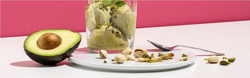 Avocado Pistazien Nicecream mit einer halben Avocado daneben