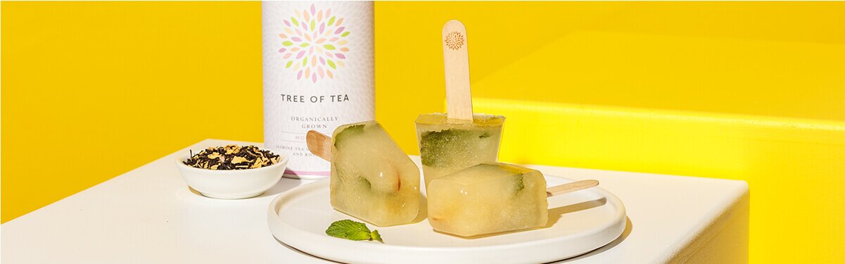 Holunderblüten Minze Eis auf einem Teller mit Tee im Hintergrund