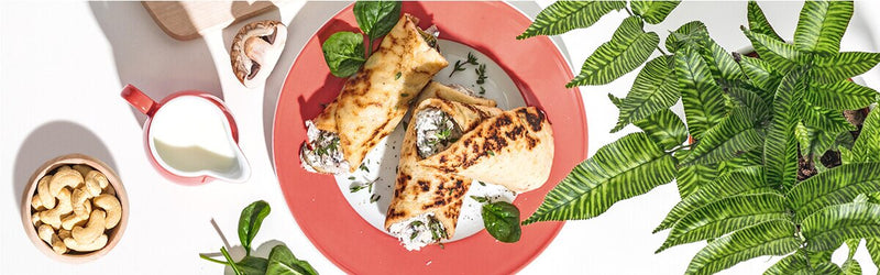 Herzhafte Pfannkuchen auf dem Teller mit einer Schale Cashews daneben