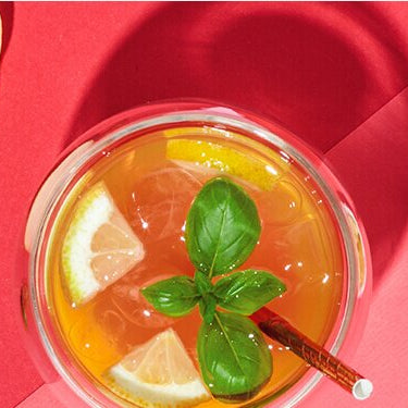 White Tropical Cocktail mit einem halben Apfel und Zitronenstücken daneben