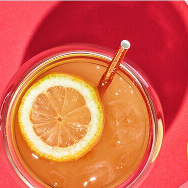 Roi Sour Cocktail mit Granatapfelkernen und Zitrone daneben