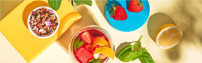 Strawberry Basil Smash im Glas und daneben Erdbeeren und eine halbe Zitrone