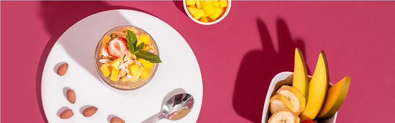 Mango Nicecream in einem Glas mit Mango und Nüssen dekoriert