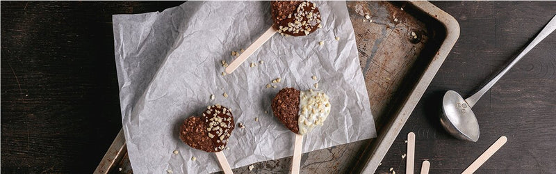 Lebkuchenherzen am Stiel auf einem Backpapier