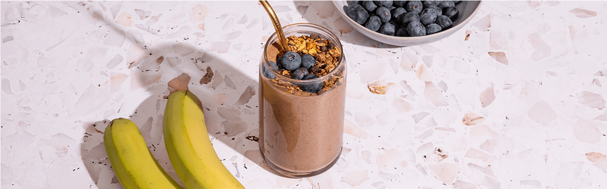 Schoko Protein Shake mit Bananen daneben