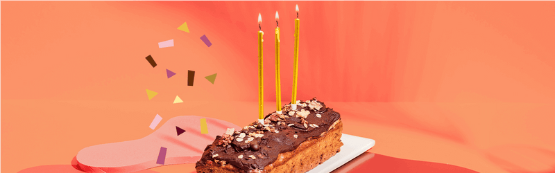 Bananenbrot auf einem Teller mit Kerzen und Konfetti