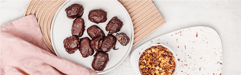 Datteln in Zartbitterschokolade auf einem Teller