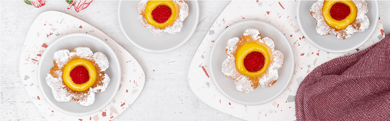 Himbeer-Lemon Curd Blumen Tartes auf Tellern