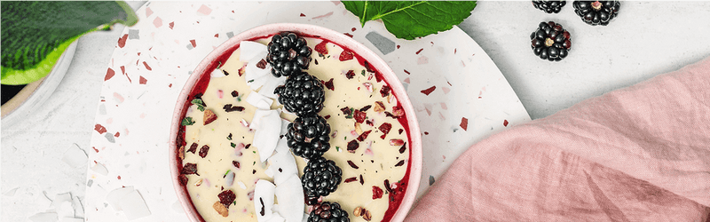 Magic Shell Smoothie Bowl mit Beeren und Kokoschips dekoriert
