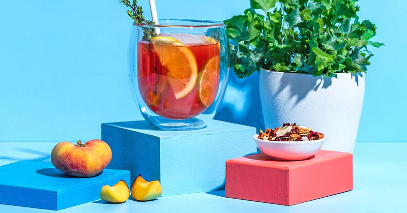 Peachy Ginger Lemonade mit Limettenscheiben und Thymian dekoriert