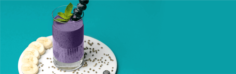 Protein Smoothie auf einem Teller mit Bananenscheiben dekoriert