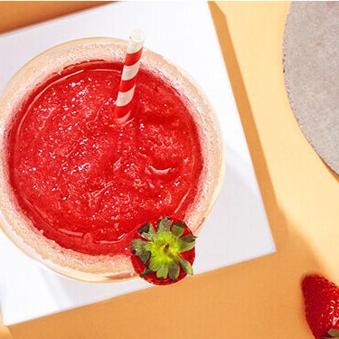 Erdbeer Frosé im Glas mit Erdbeeren daneben