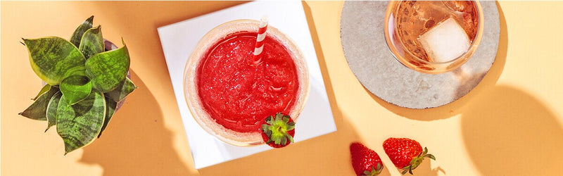 Erdbeer Frosé im Glas mit Erdbeeren daneben