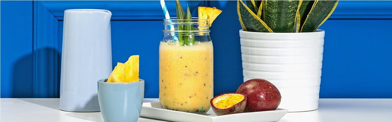 Ananas Passionsfrucht Smoothie mit einer Passionsfrucht und Ananas daneben