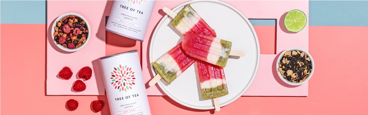 Popsicle-Eis mit Wassermelone auf einem Teller mit Teedosen daneben