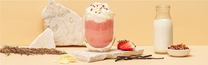 Pink Hot Chocolate mit Sahne und Erdbeeren daneben