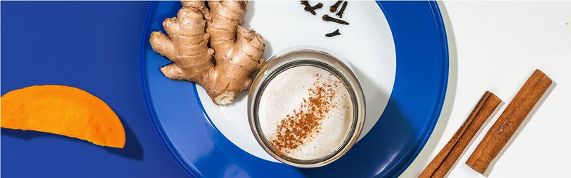 Pumpkin Spice Latte mit Zimtstangen und Ingwer dekoriert