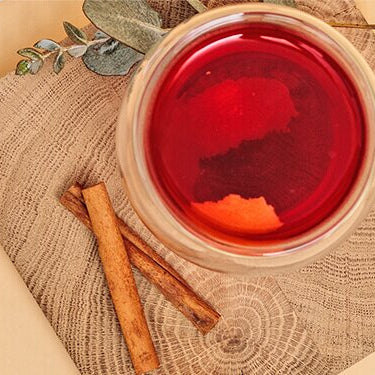 Spicy Ruby Teedrink und daneben Tee in einer Schüssel