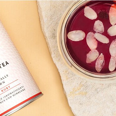 Schwedischer Glühwein mit einer halben Orange und einer Schüssel Tee daneben