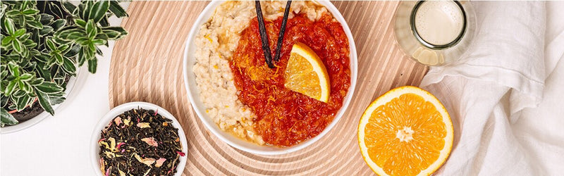 Miss Grey Porridge mit einer halben Orange und einer Schüssel Tee daneben