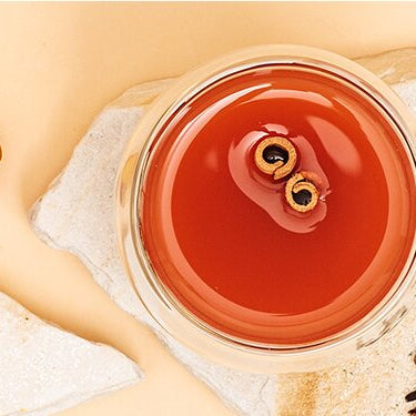 Pfirsich Punsch mit Zimtstangen und Pfirsiche daneben