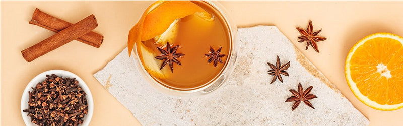 Sencha Mango Punsch mit Gewürzen und einer halben Orange