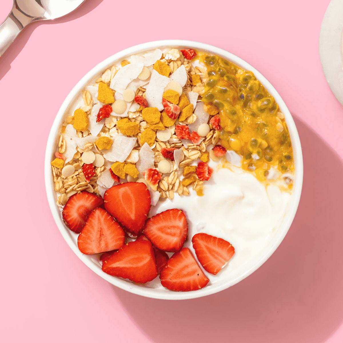 mymuesli Bio Sommer Müsli in Schüssel mit Joghurt, frischen Erdbeeren und Passionsfrucht
