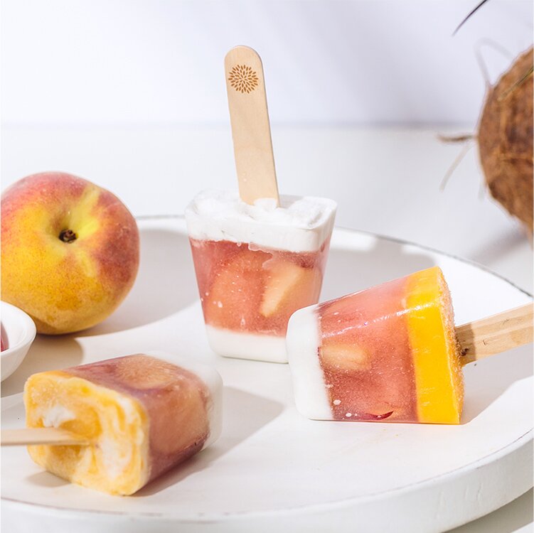 Pfirsich Kokos Eis auf einem Teller und eine Pfirsich daneben