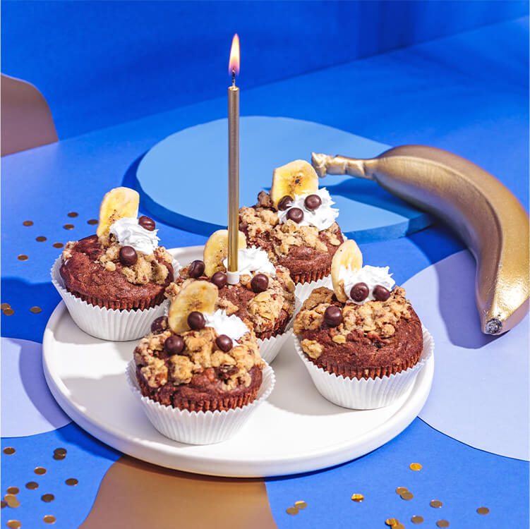 Schoko Muffins auf einem Teller und eine Banane daneben