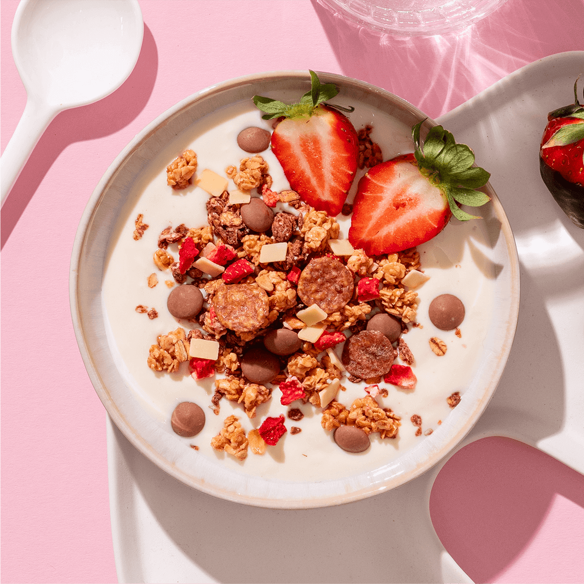 mymuesli Bio Strawberry Yoghurt Crunch in Schale mit Joghurt und frischen Erdbeeren