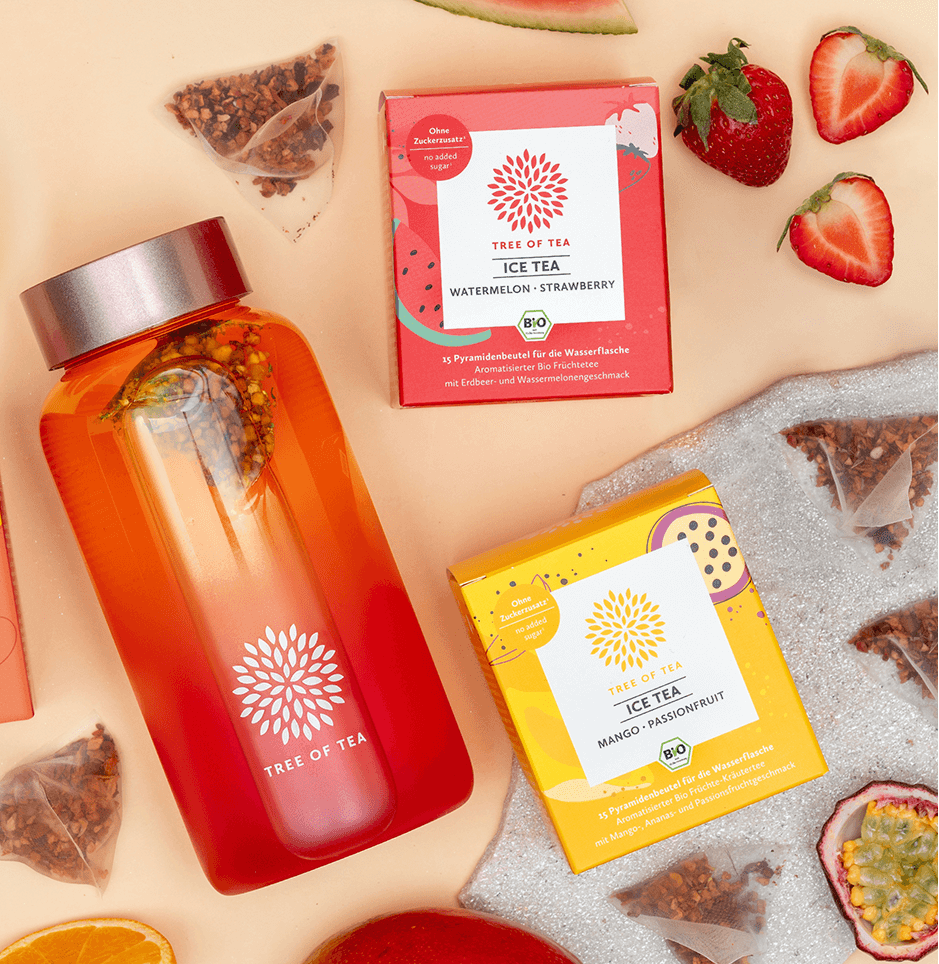 Tree of Tea Ice Tea Starter Set mit einer aufgefüllten Ice Tea bottle in Rosa. Drumherum liegen die enthaltenen Ice Tea Sorten mit frisch aufgeschnittenen Erdbeeren, Wassermelone, Mango und Passionsfrucht.