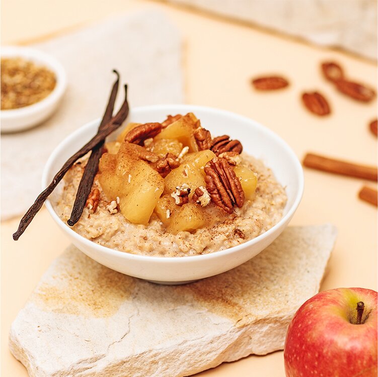 Winterporridge in einer Schüssel mit Pekannüssen und Apfelstücken dekoriert